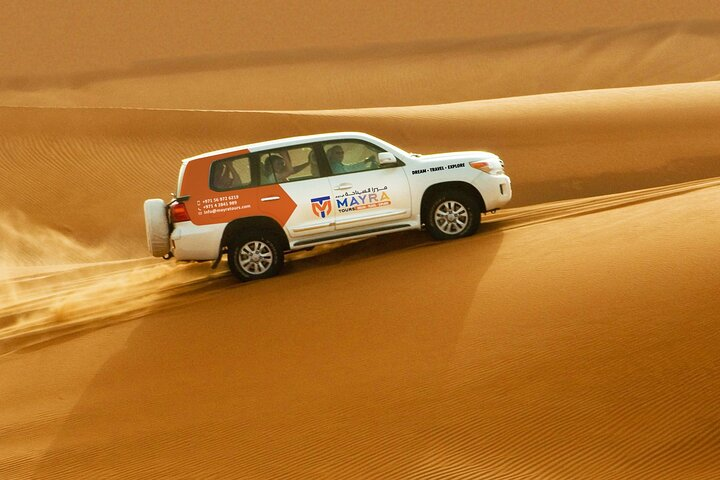 Experience the exhilarating rush of desert dunes as you embark on a camel ride and dune buggy adventure showcasing the stunning landscape of Dubai's captivating desert.